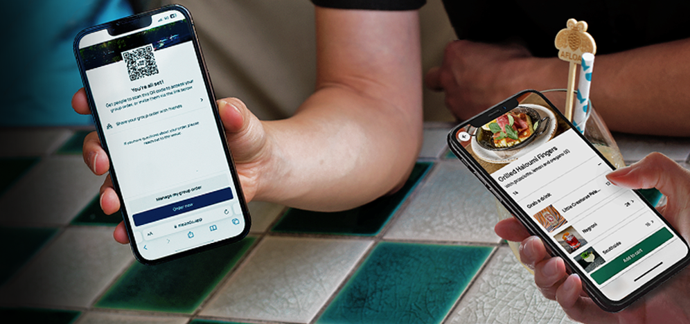 Two hands holding smartphones displaying a group tab QR code and menu items over a checkered table